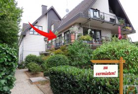 7-Familienhaus mit begrüntem Vorgarten und Schild zu verkaufen