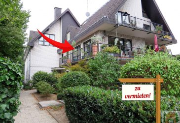 7-Familienhaus mit begrüntem Vorgarten und Schild zu verkaufen